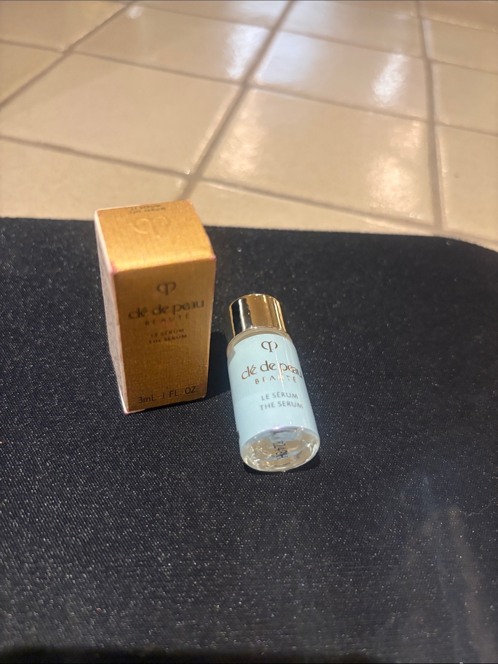 cle de peau gold and light blue serum bottle